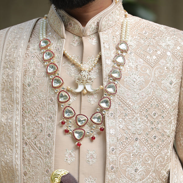 Man wearing a traditional embroidered sherwani with jewelry