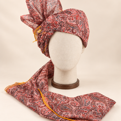 Front view of blush pink paisley Barati Safa with red and charcoal motifs and mustard yellow edging
