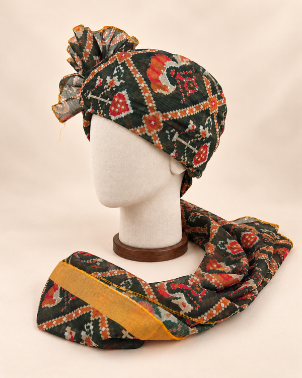 Left side view of dark green geometric print Barati Safa with red ochre motifs and broad mustard edge
