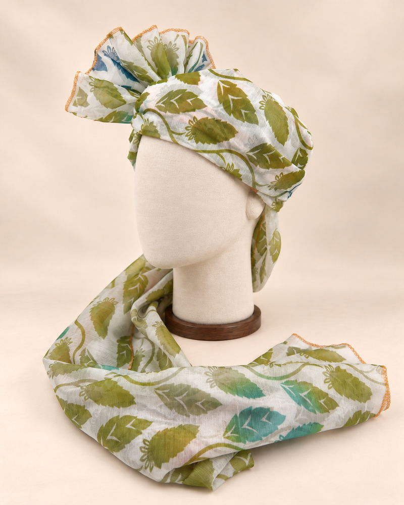 Left side view of ivory green leaf print barati safa showing the smooth wrap and long patterned tail