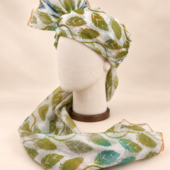 Left side view of ivory green leaf print barati safa showing the smooth wrap and long patterned tail