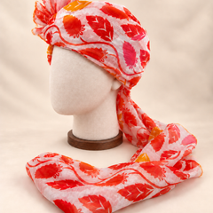 Left side view of ivory red leaf print barati safa showing the smooth wrap and long patterned tail