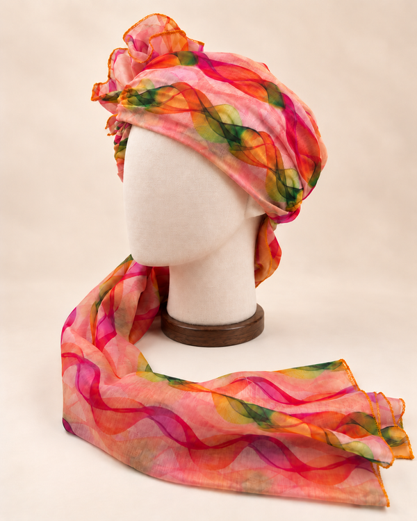 Left side view of multicolour wave print barati safa showing the smooth wrap and long patterned tail