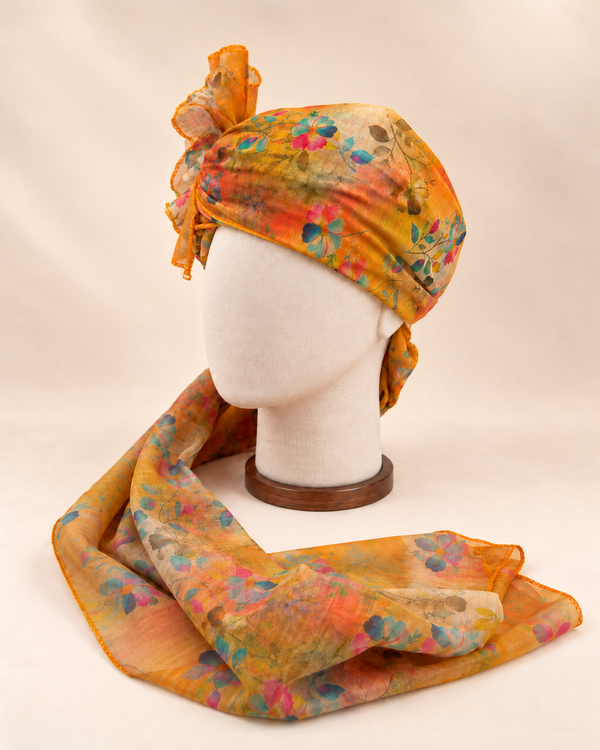 Left side view of mustard multicolour floral print barati safa showing the smooth wrap and long patterned tail