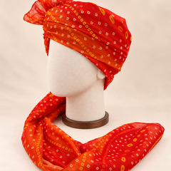Left side view of orange gold dot bandhani print barati safa showing the smooth wrap and long patterned tail