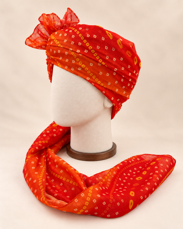Left side view of orange gold dot bandhani print barati safa showing the smooth wrap and long patterned tail