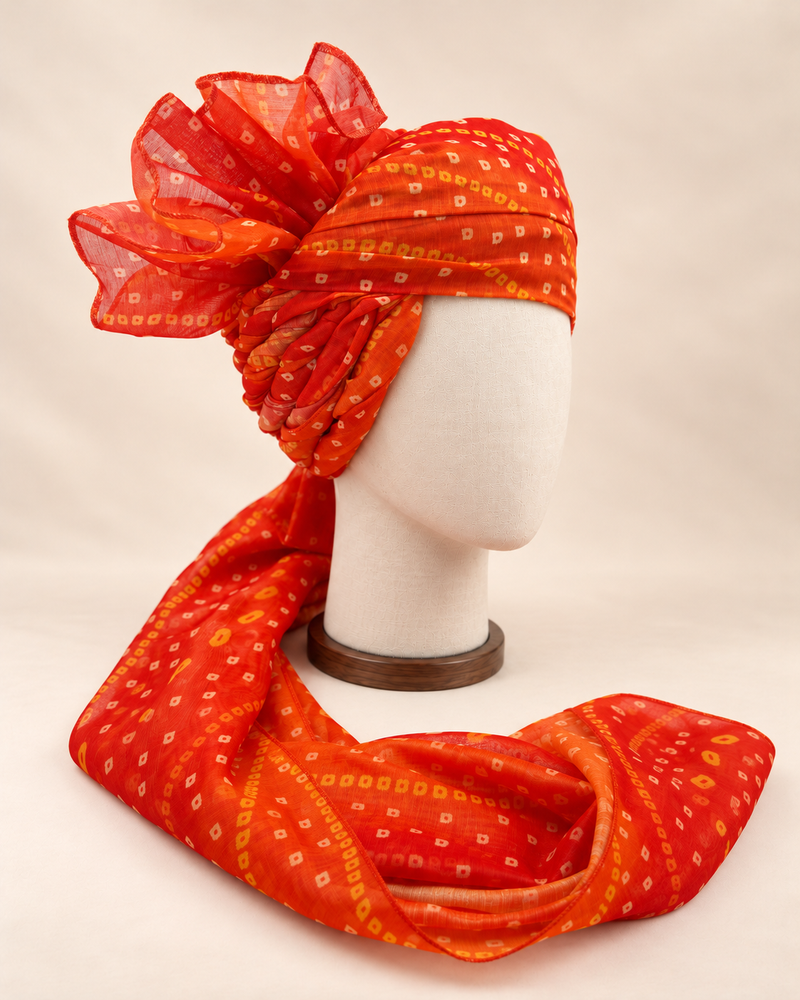 Right side view of orange gold dot bandhani print barati safa showing twisted folds and fan detail
