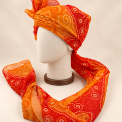 Left side view of orange paisley bandhani print barati safa showing the smooth wrap and long patterned tail