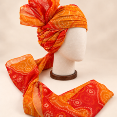 Right side view of orange paisley bandhani print barati safa showing twisted folds and fan detail