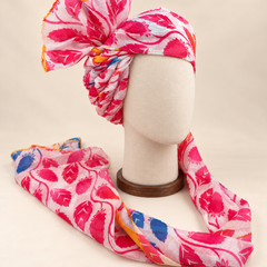 Right side view of pink white leaf print Barati Safa showing twisted folds and yellow-edged fan