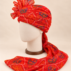 Left side view of red blue bandhani print barati safa showing the smooth wrap and long patterned tail