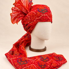 Right side view of red blue bandhani print barati safa showing twisted folds and fan detail
