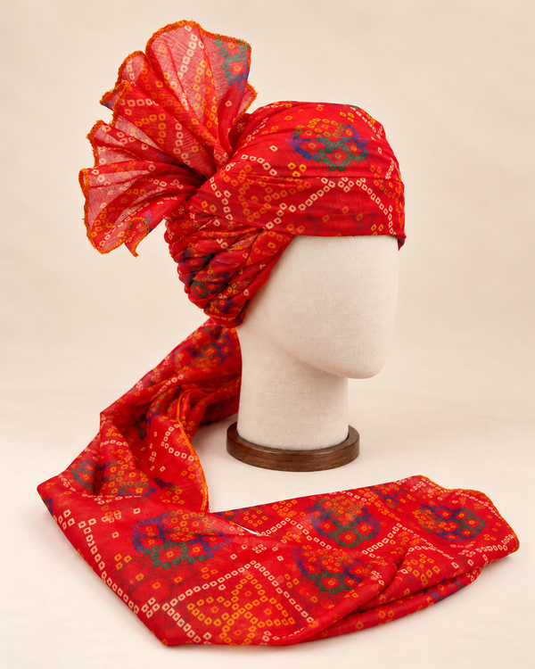 Right side view of red blue bandhani print barati safa showing twisted folds and fan detail