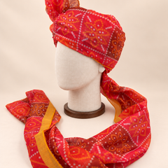 Left side view of red diamond bandhani print barati safa showing the smooth wrap and long patterned tail