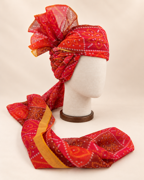 Right side view of red diamond bandhani print barati safa showing twisted folds and fan detail