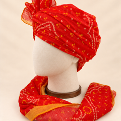 Left side view of red gold paisley bandhani print barati safa showing the smooth wrap and long patterned tail
