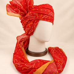 Right side view of red gold paisley bandhani print barati safa showing twisted folds and fan detail