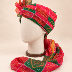Left side view of red green bandhani print barati safa showing the smooth wrap and long patterned tail
