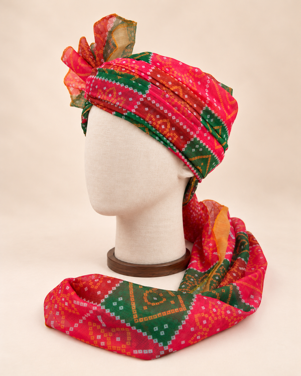 Left side view of red green bandhani print barati safa showing the smooth wrap and long patterned tail