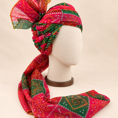 Right side view of red green bandhani print barati safa showing twisted folds and fan detail