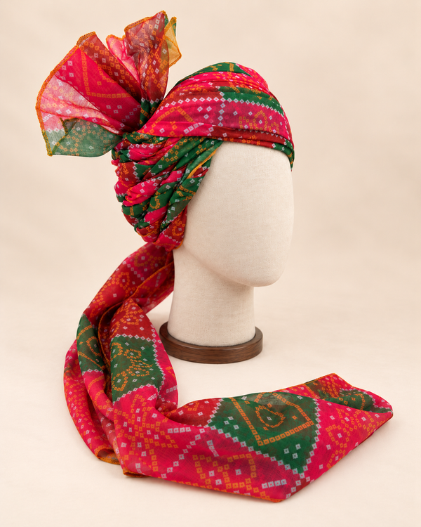 Right side view of red green bandhani print barati safa showing twisted folds and fan detail
