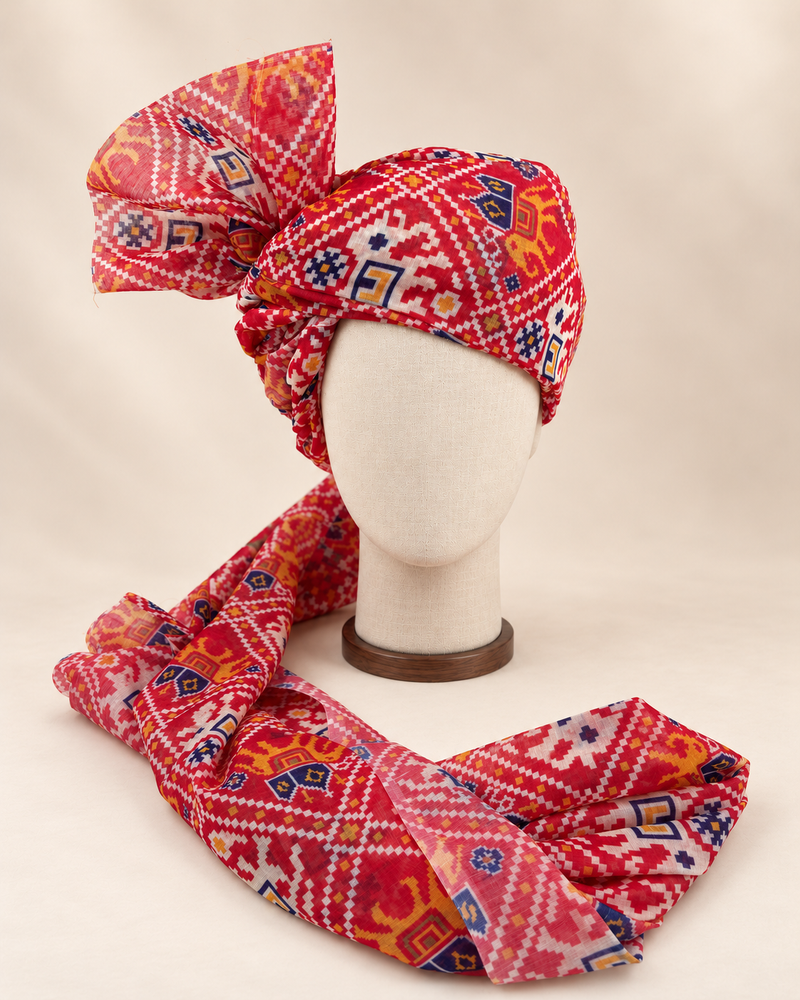 Front view of red ikat geometric print barati safa showing the patterned wrap and fan